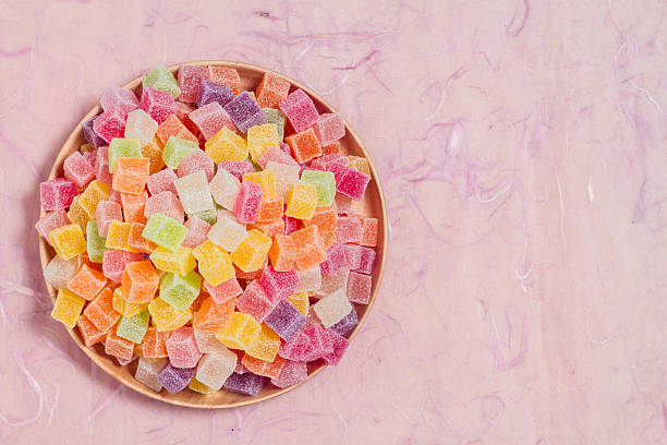 istock Colorful candy and jelly in dish on pink background 599996130