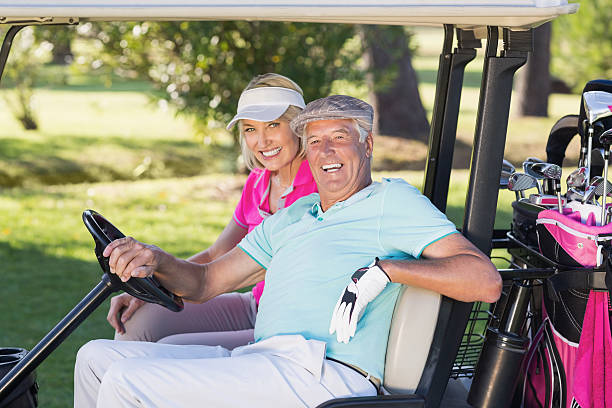 istock Cheerful mature golfer couple sitting in golf buggy 599997754