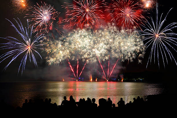 bela exibição de fogos de artifício coloridos com multidões irreconhecíveis assistindo - canada day fotos - fotografias e filmes do acervo