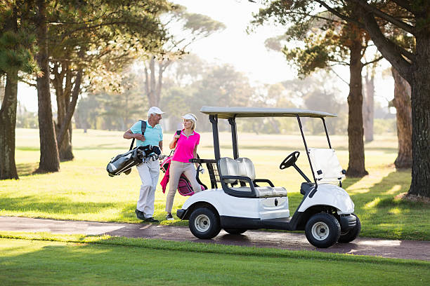 istock Smiling mature golfer couple by golf buggy 599998422