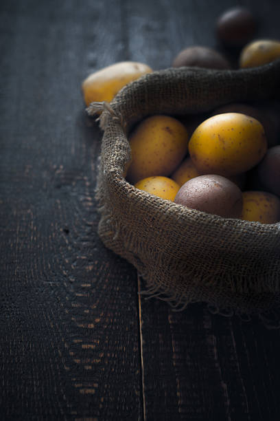 istock Potatoes in the canvas bag  on the wooden table vertical 599998884