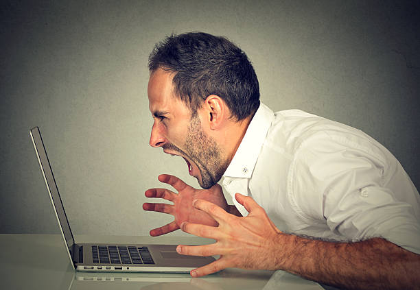 Angry furious business man screaming at computer. Negative human emotions, facial expressions, feelings, aggression, anger management issues concept