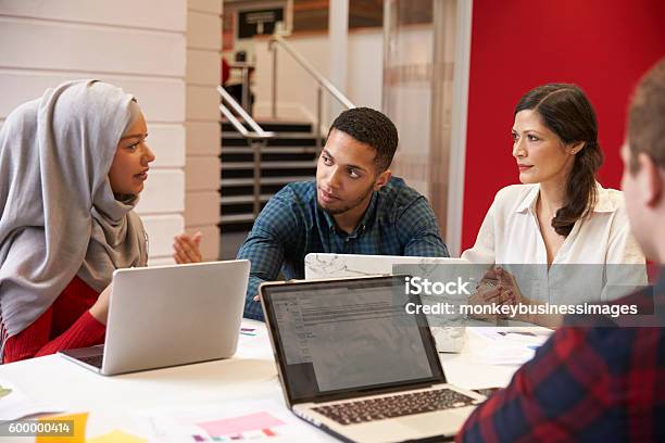 Group Of Students Meeting For Tutorial With Teacher Stock Photo - Download Image Now