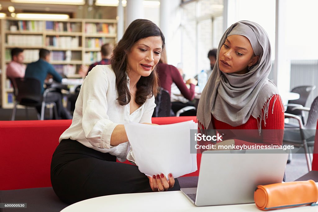 Studentin der Studentin arbeitet in der Bibliothek mit Tutor - Lizenzfrei Lehrkraft Stock-Foto
