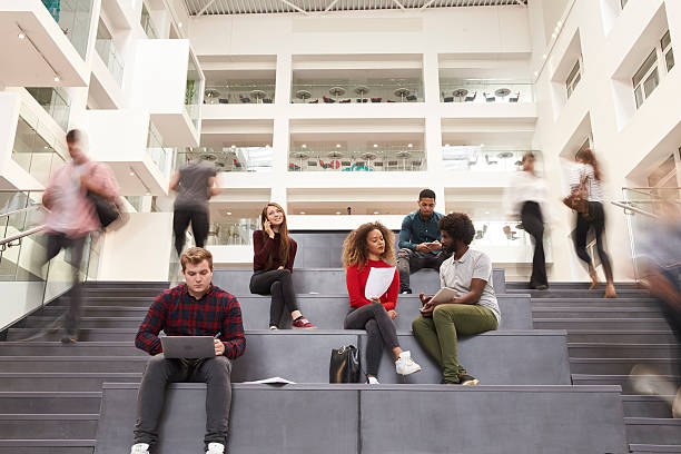 interior del concurrido edificio del campus universitario con estudiantes - campus fotografías e imágenes de stock