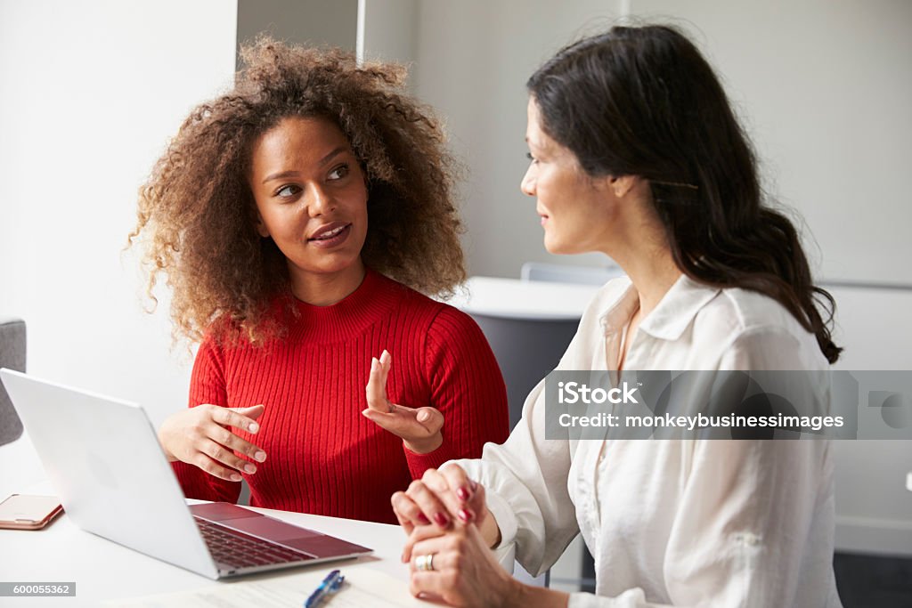 Female University Student Working One To One With Tutor Teacher Stock Photo