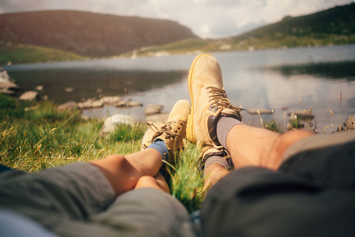 A couple lying in a tent near by the lake.