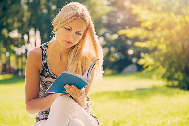 istock Woman resting and enjoying a book reading at the lawn. 600059862