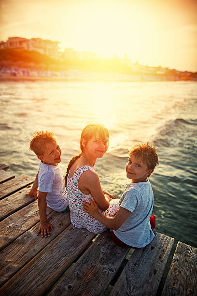 istock Summer vacations - happy kids on pier 600062116