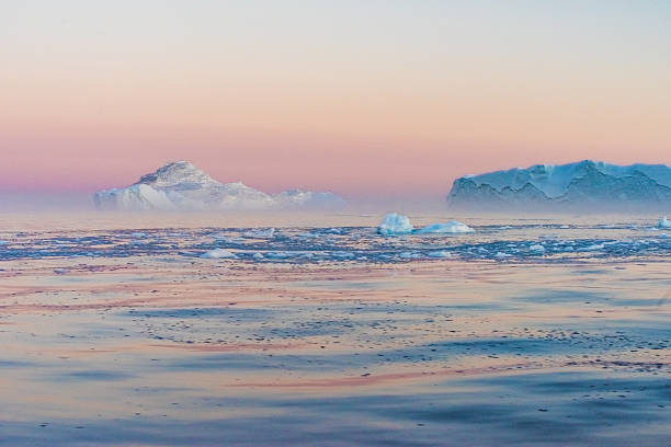 Icebergs in the midnight sun, Ilulissat, Greenland Huge stranded icebergs at the mouth of the Icejord near Ilulissat at midnight, Greenland arctic ocean photos stock pictures, royalty-free photos & images