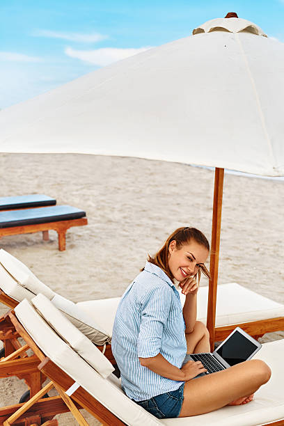 istock Summer Work. Woman Relaxing Using Computer On Beach. Freelance Business 600064514