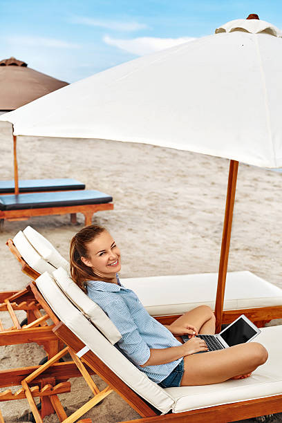 istock Summer Work. Woman Relaxing Using Computer On Beach. Freelance Business 600064608
