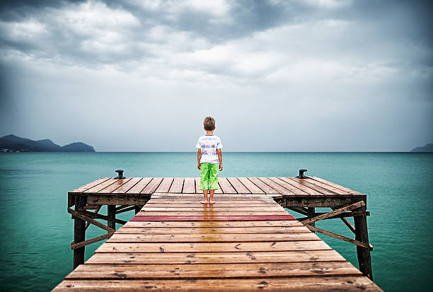 istock Little boy at sea pier 600066146