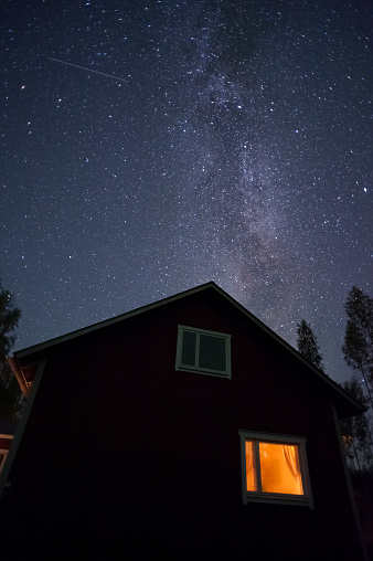 Milky Way and stars above old house