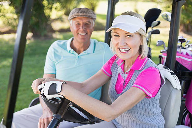 istock Smiling mature couple sitting in golf buggy 600068514