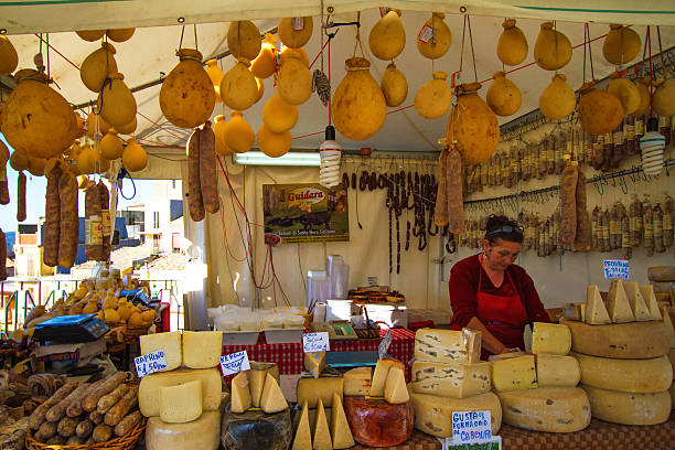 Vizzini, Sicily, Italy - April 25, 2014:  A vendor selling cheese and salami at an outdoor booth in Vizzini's annual ricotta festival. Vizzini is in the province of Catania.
