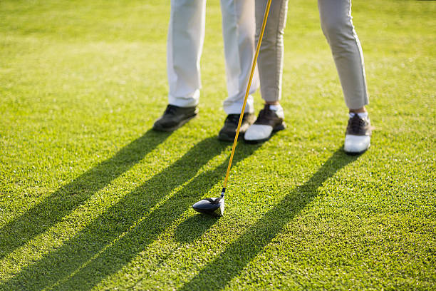 istock Low section of couple playing golf on grass 600068726