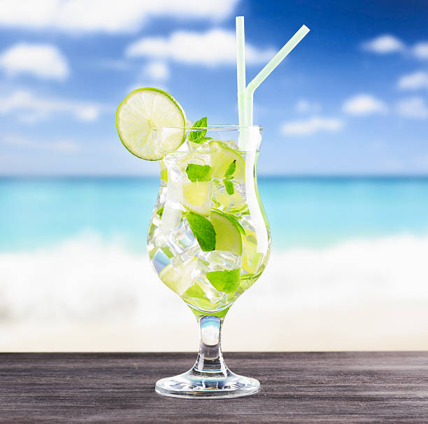 istock Glass of mojito cocktail on a beach 600069612