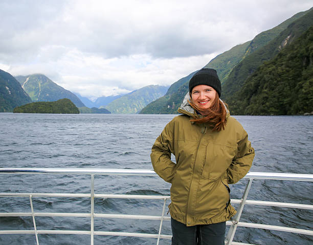 istock Young smiling woman  standing on the boat deck. NZ 600071910