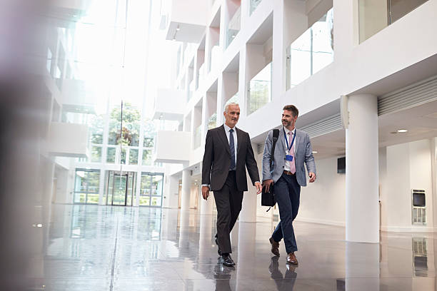 istock Businessmen Talking As They Walk Through Office Lobby 600072028