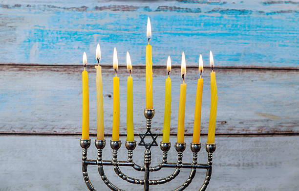 istock Hanukkah menorah with candles and silver dreidel. 600072192