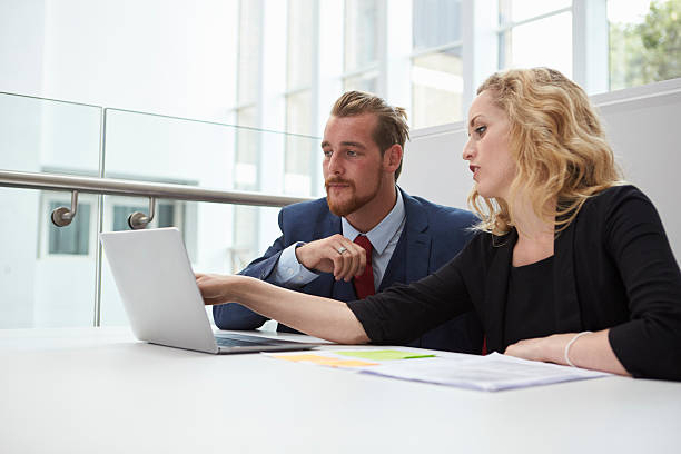 istock Two Businesspeople Using Laptop At Desk In Modern Office 600072358