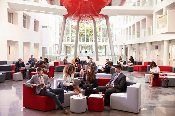 istock Businesspeople Using Digital Devices In Busy Office Lobby 600072442