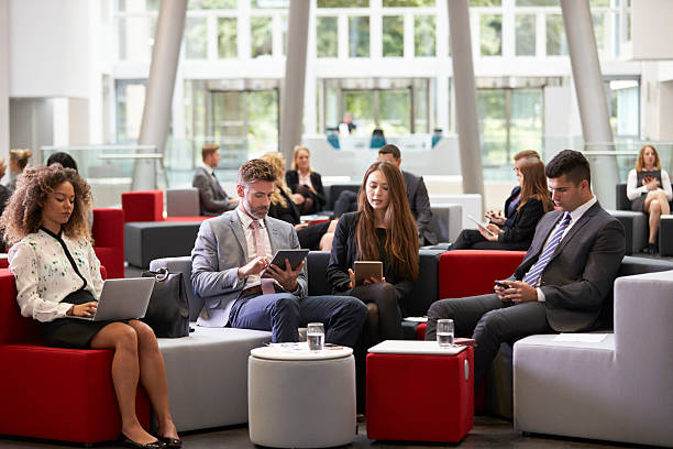 istock Businesspeople Using Digital Devices In Busy Office Lobby 600072460