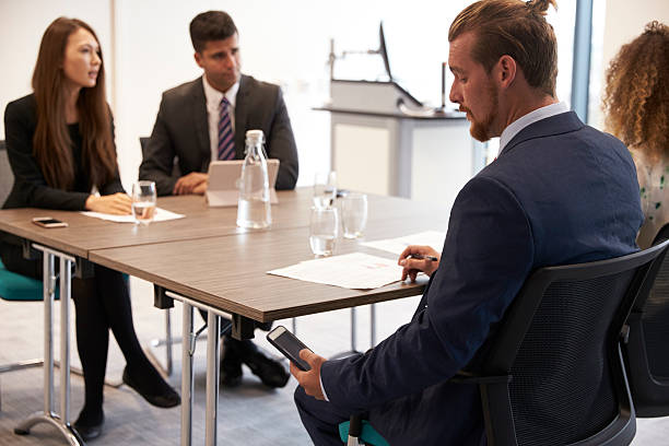 istock Businessman Receiving Text Message During Meeting 600072526