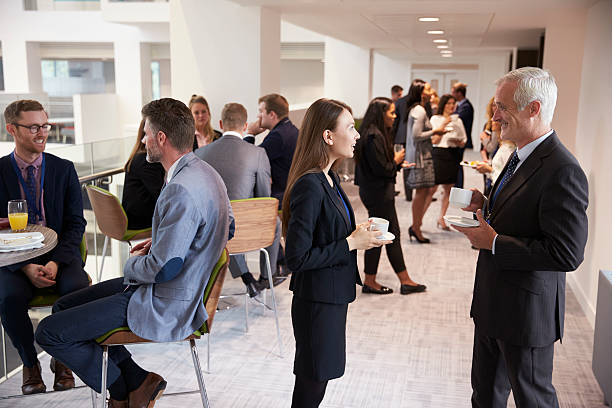 les délégués se sont networkings pendant la pause-café à la conférence - pause café photos et images de collection