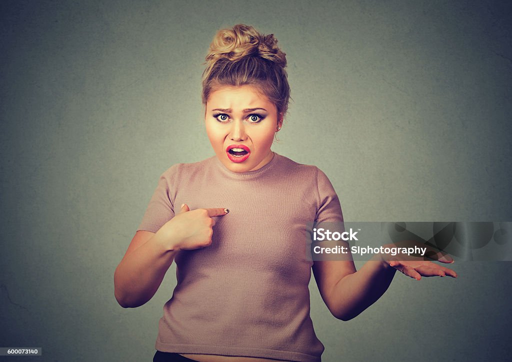 angry, annoyed woman, you talking to me? Closeup portrait of angry, unhappy, annoyed young woman, getting mad, asking question you talking to me, you mean me? Isolated on gray background. Negative human emotions, facial expressions Adult Stock Photo