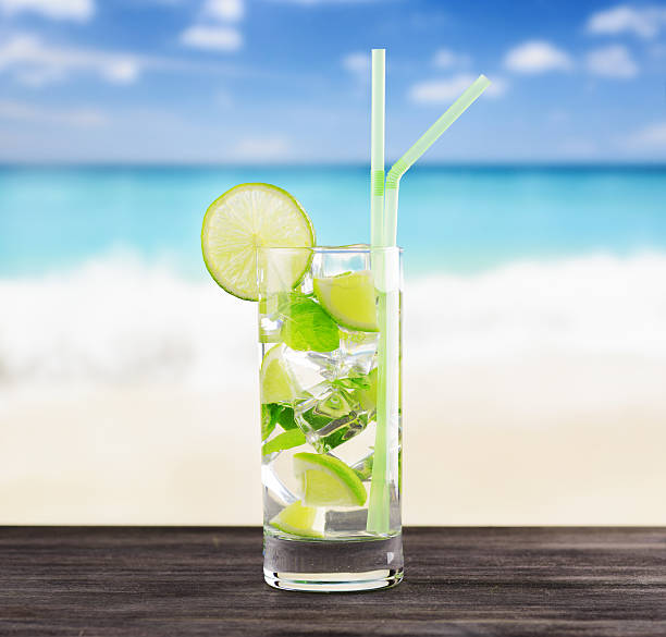 istock Glass of mojito cocktail on a beach 600073278