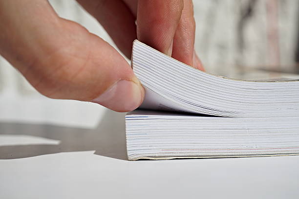 istock Male fingers turning pages and opening a thick book 600073352