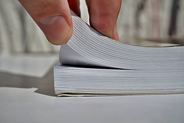 istock Male fingers turning pages and opening a thick book 600073392