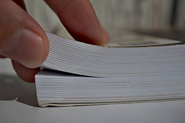 istock Male fingers turning pages and opening a thick book 600073430