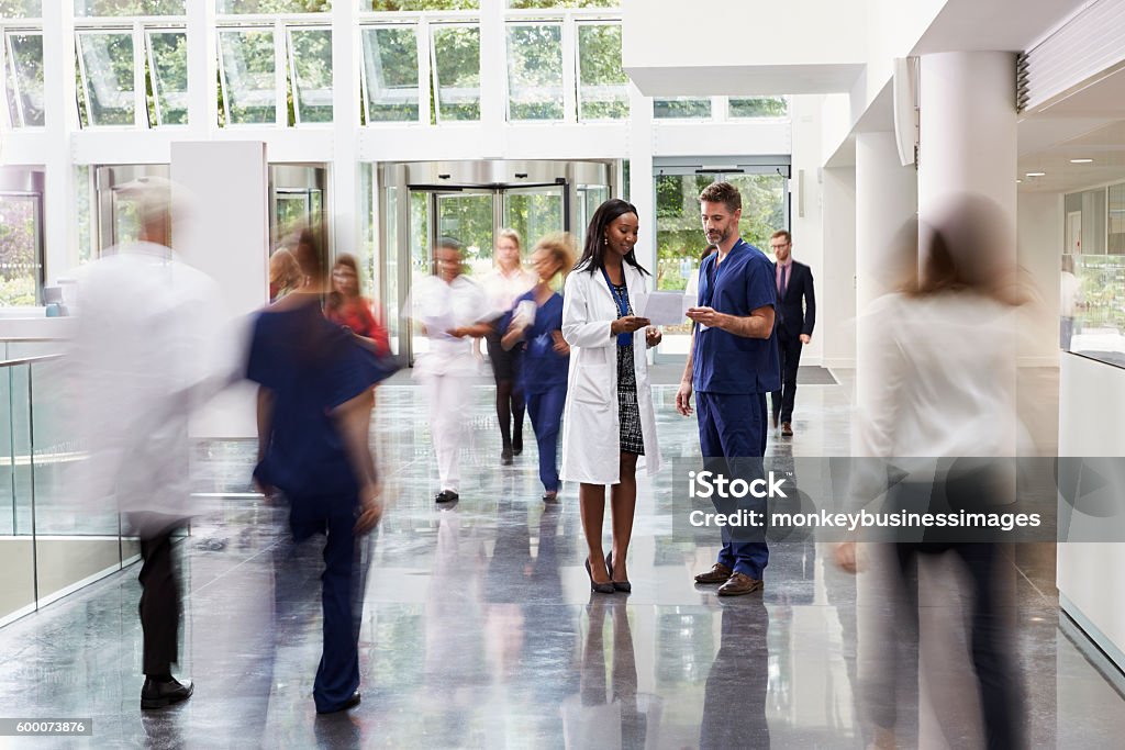 Personel w ruchliwym holu nowoczesnego szpitala - Zbiór zdjęć royalty-free (Szpital)