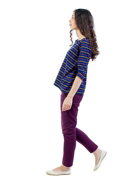 istock back view of walking  curly woman. 600084308