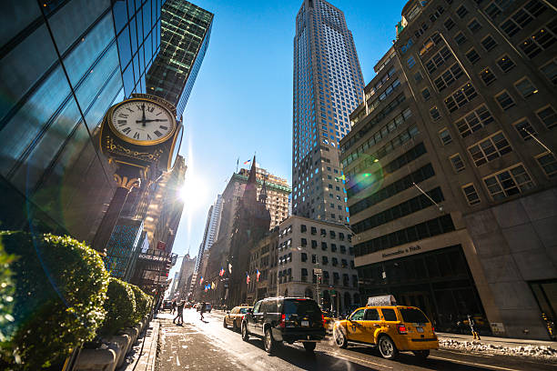 New York, USA  - January 24, 2014: Fifth Avenue with luxury shops and people walking, NYC. Trump Tower on left side. Cars moving on 5th avenue. 