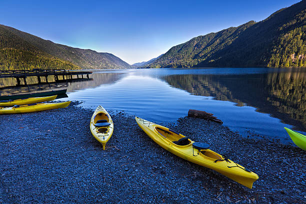 Water Sport Kayak at Lake Crescent Olympic National Park Olympic National Park in Washington State of United States. Water sport of canoes and kayaks at Lake Crescent. The scenic park is located west of the City of Seattle and Tacoma in Washington State. Photographed in horizontal format at predawn sunrise. olympic peninsula photos stock pictures, royalty-free photos & images