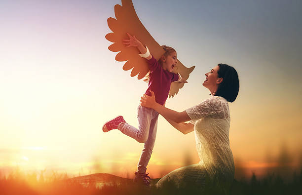Mother and her child playing Mother and her daughter child playing together. Little girl plays in the bird. Happy loving family having fun. women flying bird freedom stock pictures, royalty-free photos & images