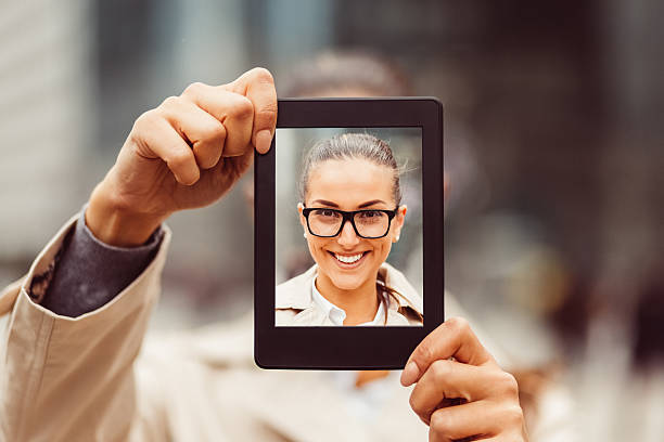 Selfie with tablet Smiling girl taking selfie with tablet obscured face photos stock pictures, royalty-free photos & images