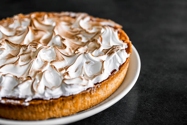 Homemade lemon meringue pie baked shot on dark kitchen island stock photo