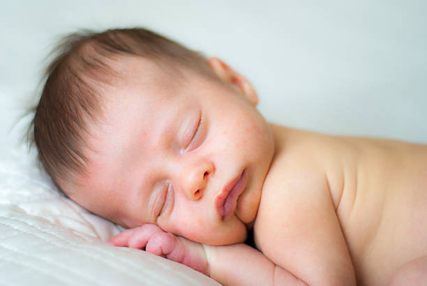 istock Newborn Baby Boy Sleeping on White Blanket 600091808