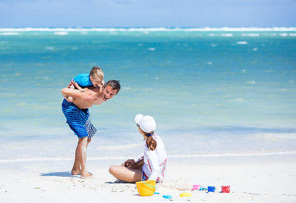 istock Family of three playing on the beach 600098826