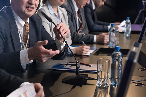 Group of business people sitting in a line at conference