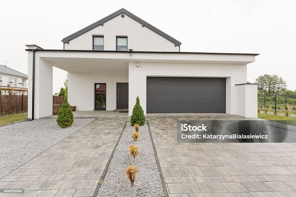 New design white villa Exterior view of a modern white mansion with a garage and stone driveway Driveway Stock Photo