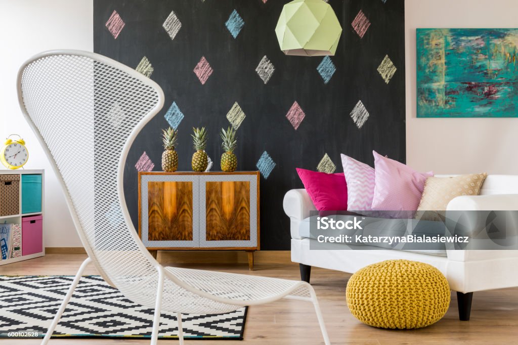 Relax in colorful interior Colorful interior in new style with blackboard, exotic commode, sofa, pouffe and white chair Apartment Stock Photo