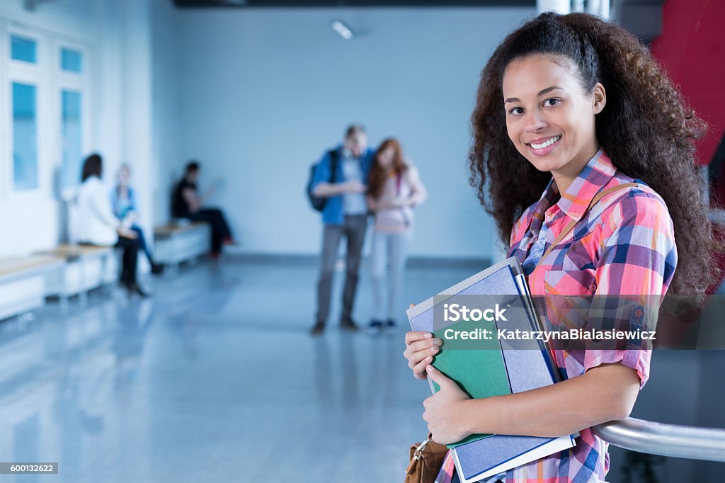University student in college holding notes Smiling female university student holding notes indoor Aspirations Stock Photo