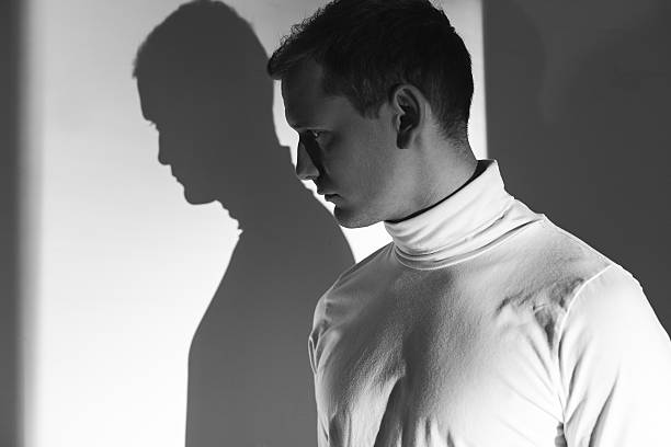 istock Young man afraid of his own shadow 600133394
