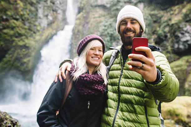 istock Hiking Couple Take Selfie by Waterfall 600134740